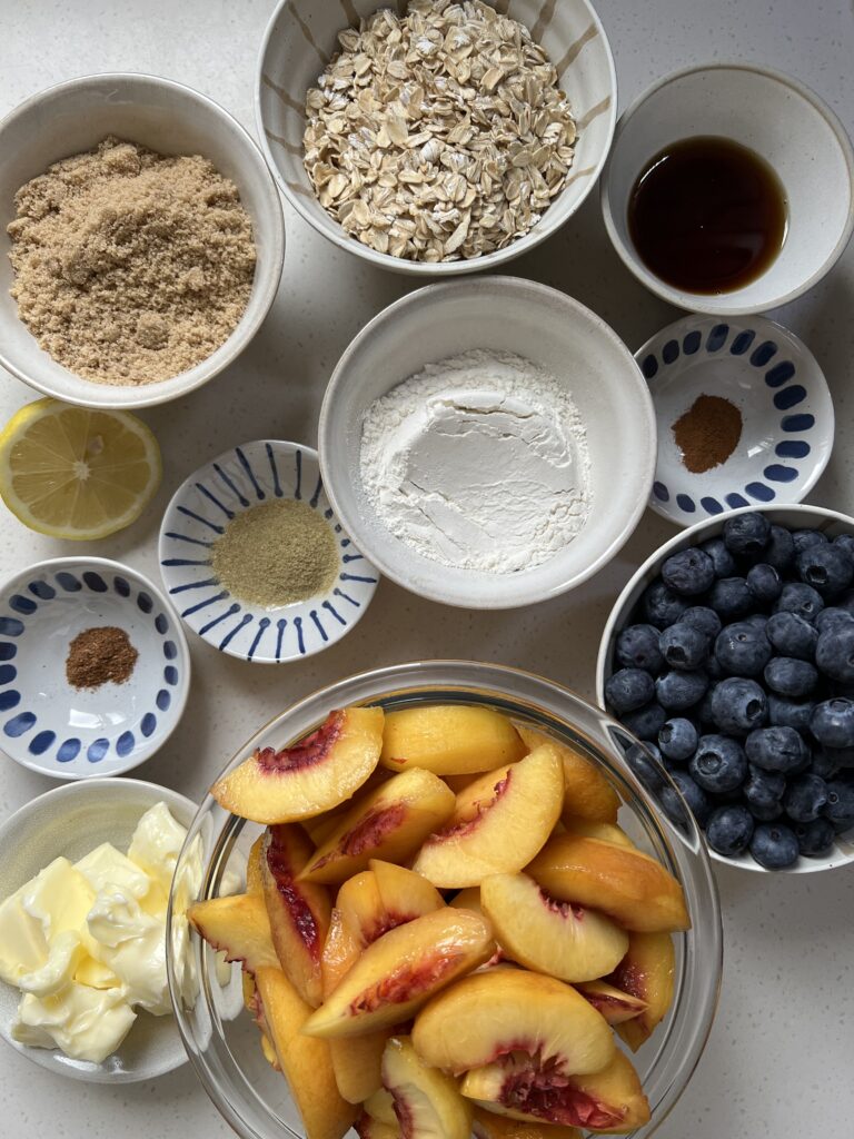 Ingredients for the Served Seasonal Blueberry and Nectarine Skillet Crisp. Whole rolled oats, brown sugar, maple syrup, flour, cardamom, cinnamon, nutmeg, butter, nectarines, blueberries, lemon juice and zest.