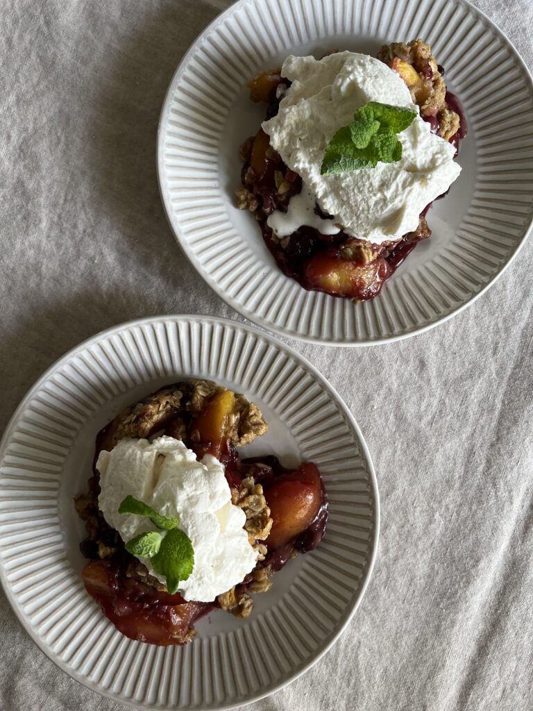 Served Seasonal Blueberry and Nectarine Skillet Crisp topped with the Served Seasonal Salted Maple Whipped Cream.