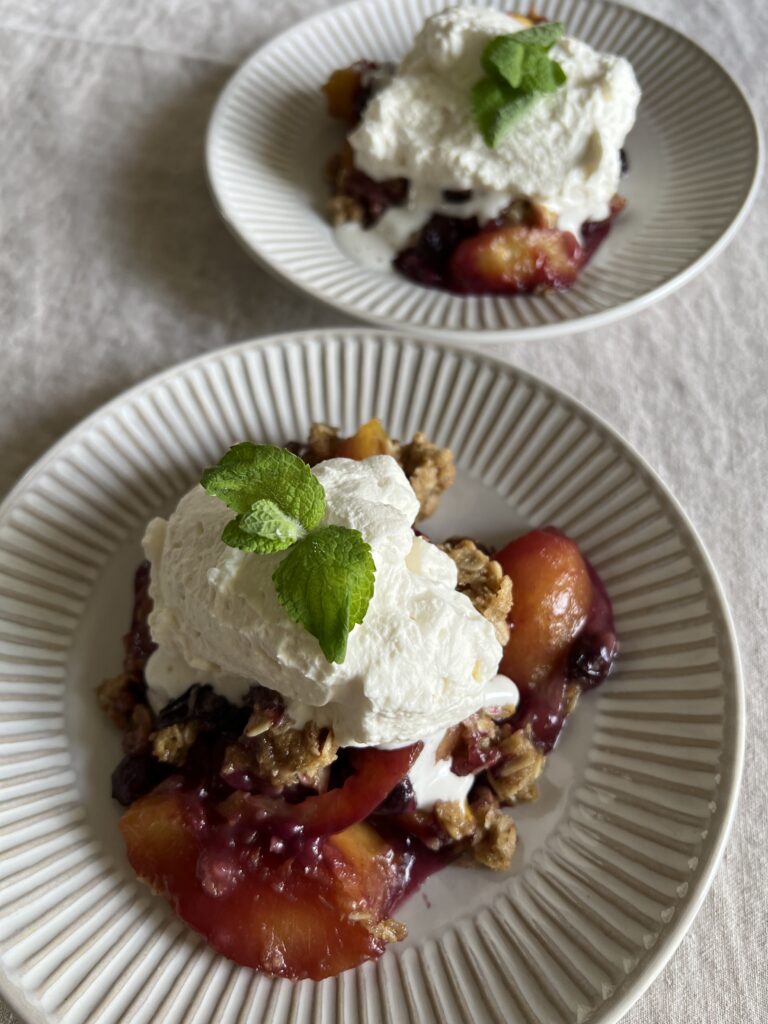 Served Seasonal Salted Maple Whipped Cream served on top of the Blueberry and Nectarine Skillet Crisp.