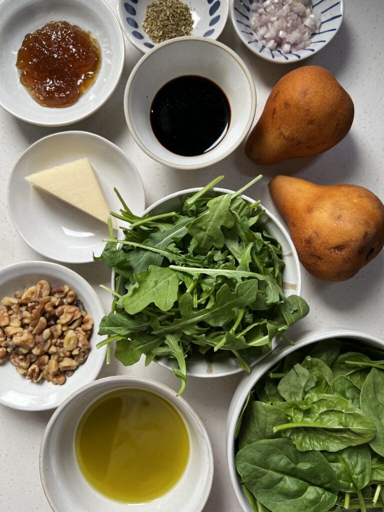 Ingredients for the Served Seasonal Pear and Walnut Salad. Fig preserves, dried oregano, minced shallot, parmesan cheese, balsamic vinegar, fresh pears, chopped walnuts, arugula, spinach, and olive oil.