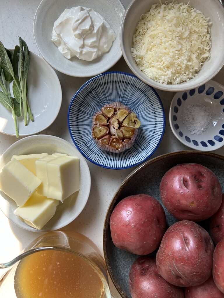 Ingredients for Served Seasonal Instant Pot Mashed Potatoes. Red potatoes, butter, sage, stock, roasted garlic, salt, parmesan cheese, and sour cream.