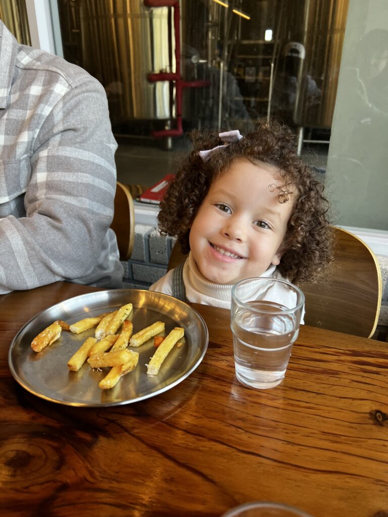 My daughter enjoying fries at the restaurant.
