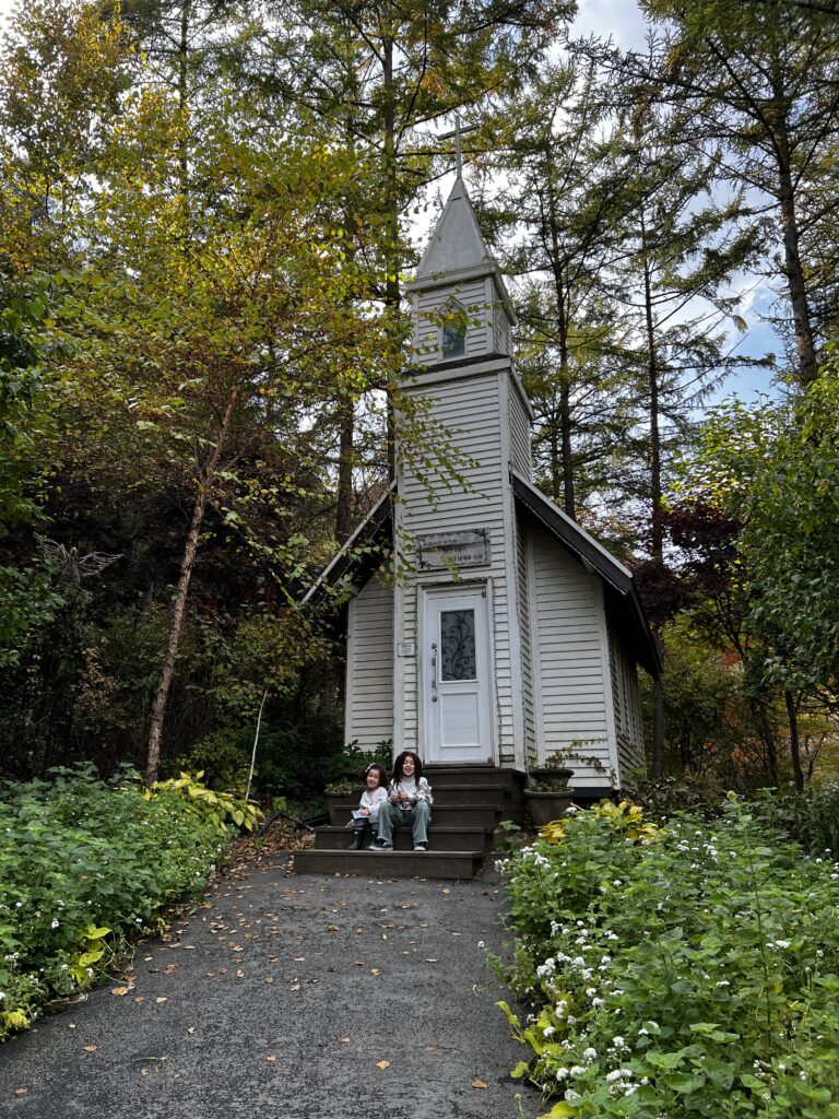 My daughters sitting in front of a little chapel.
